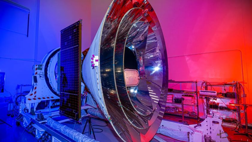 a large silver cone-shaped spacecraft in a white cleanroom