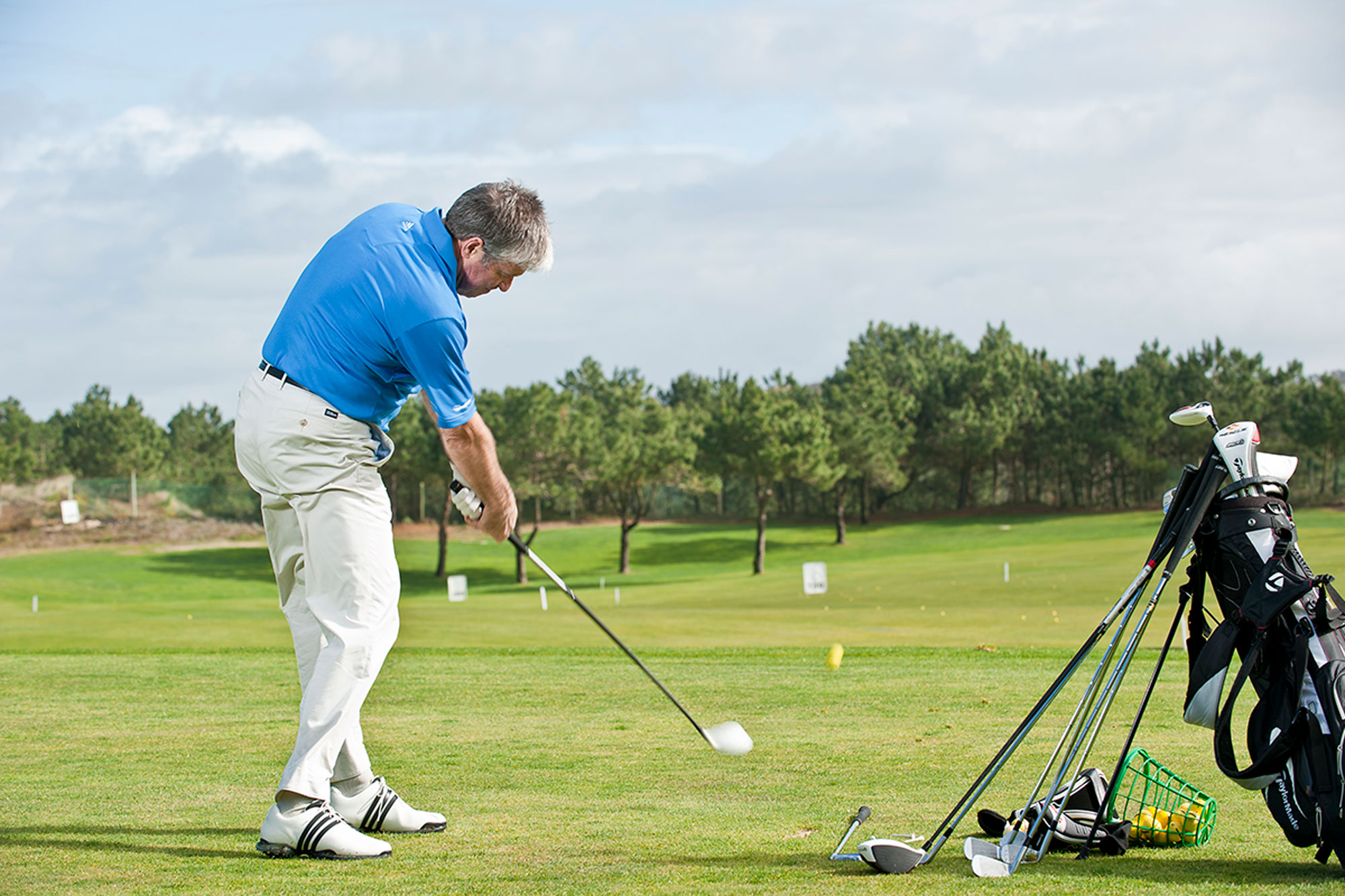 Andrew Reynolds hitting a shot with driver during his golf warm-up on the range before heading out for a round of golf