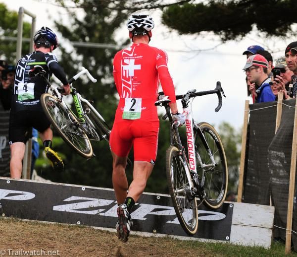 Christian Heule (Cannnondale p/b Cyclocrossworld.com) running with team-mate Johnson