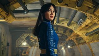 Lucy MacLean (Ella Purnell) in her blue and yellow Vault Suit inside Vault 33 in the Fallout TV show. 