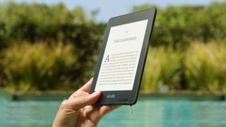 A Kindle being read by a lake