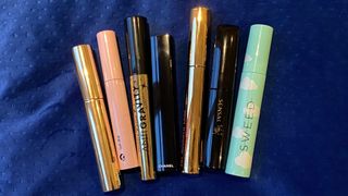 a variety of mascaras included in the best tubing mascaras buying guide on a blue velvet background