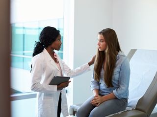 young girl speaking with doctor in a clinic