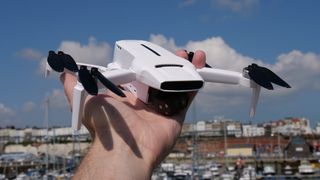 A hand holding the FIMI X8 Mini drone