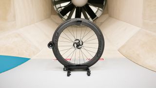 A front FFWD Ryot 55 wheel sits in front of the fan within a wind tunnel