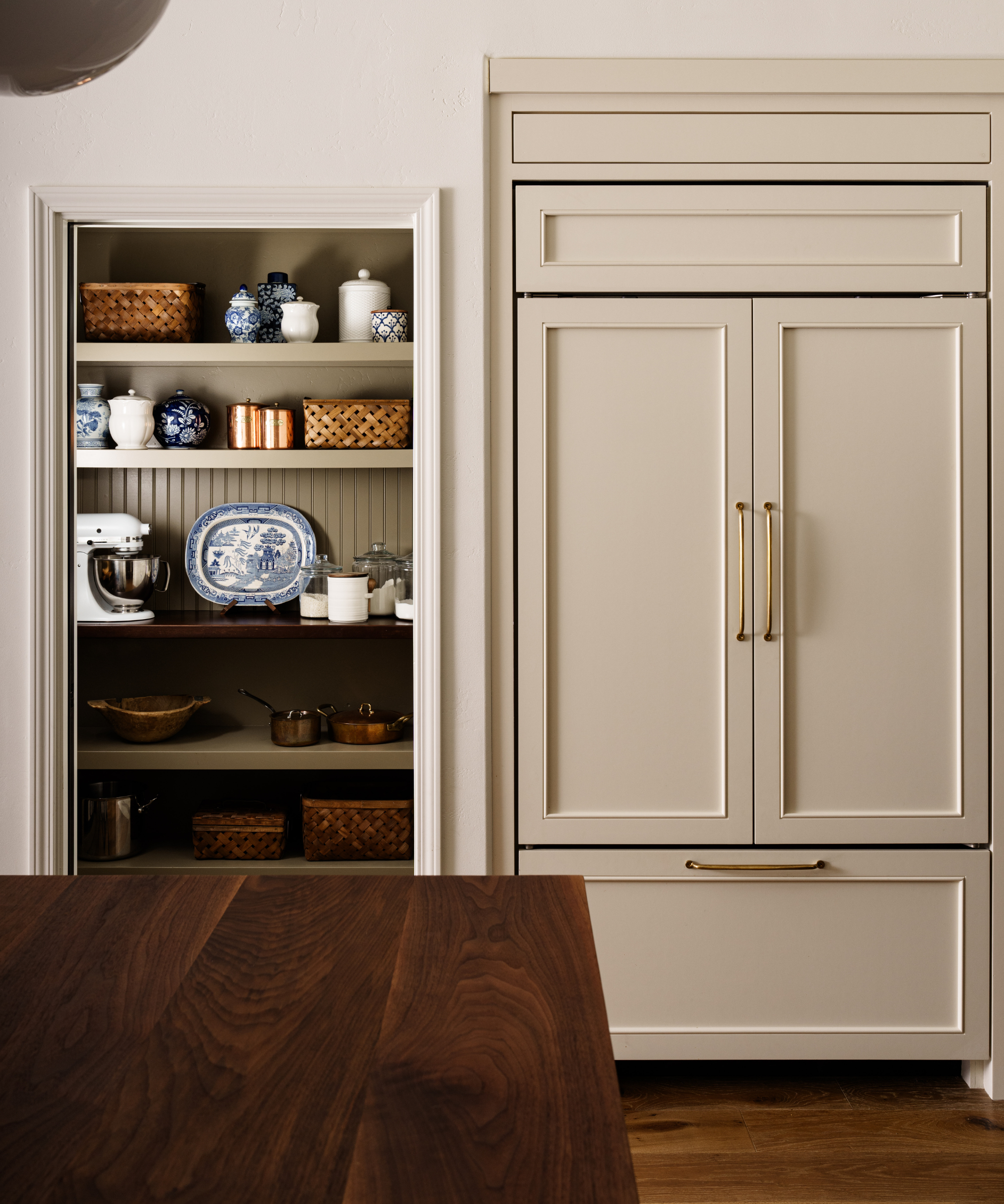 a kitchen pantry with decorative objects, chinoiserie, and kitchen supplies on the shelves