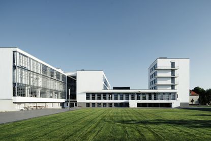 The Bauhaus school building, predominantly white in colour with a large field in front. 