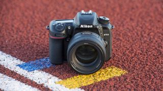 Et kamera av typen Nikon D7500 på en idrettsbane.