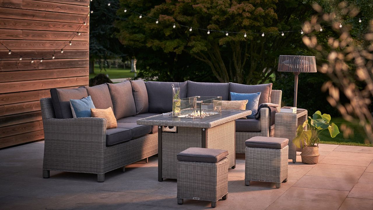 fire pit table on a patio with festoon lighting