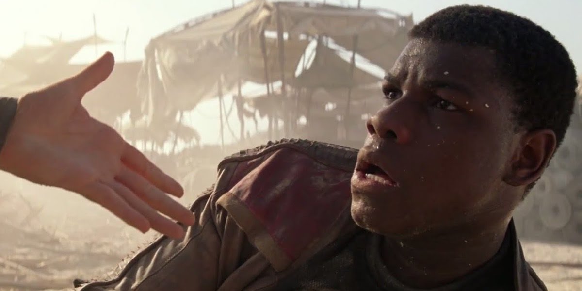 John Boyega as Finn with Rey&#039;s hand in Star Wars: The Force Awakens