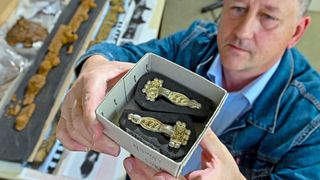 Archaeologist Arnold Muhl shows early medieval fibulae, a part of women&#039;s clothing, that were discovered in the cemetery. This and other artifacts from the excavation are now in the workshop of the Landesmuseum für Vorgeschichte (State Museum for Prehistory) in Germany. 