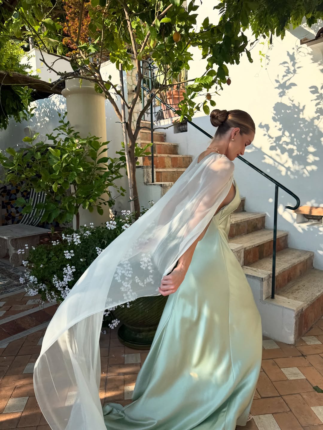 Rosie Huntington-Whiteley in a silk green dress with a cape