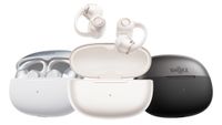 Three Shokz OpenDots 2 cases (silver, white and black) in a row, with the central white pair of earbuds jumping out of their charging case.