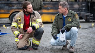 Max Thieriot as Bode Leone and Matt Lauria as Boone both kneeling on a crime scene. 
