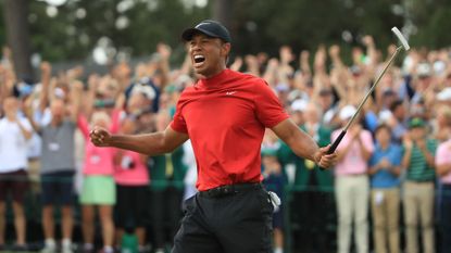 Tiger Woods (L) of the United States celebrates on the 18th green after winning the Masters at Augusta National Golf Club on April 14, 2019 