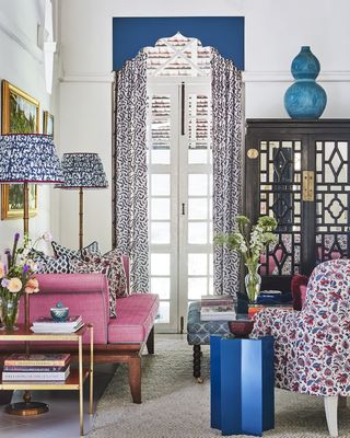 Living room with mix of pattern, pink sofa and blue pelmet