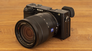 Sony A6100, one of the best beginner mirrorless cameras, on a wooden table