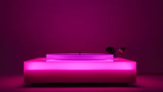 a turntable lit up in pink LEDs
