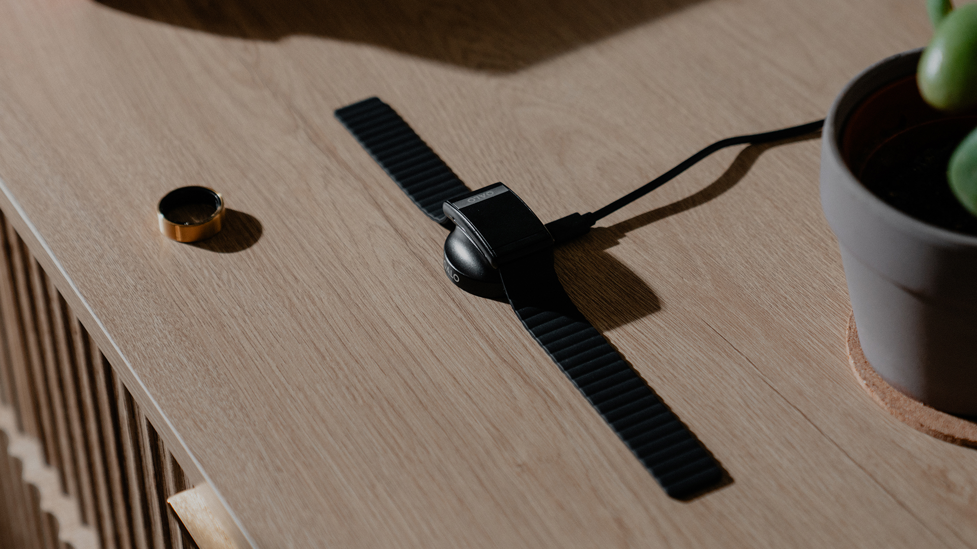 The QALO Smart band and ring on a table together