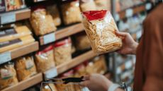 Image shows person holding pasta packet