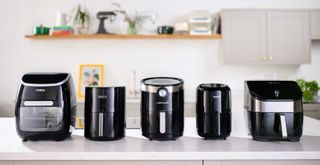 5 air fryer models lined up on a kitichen counter in the w&h test kitchen to answer 'are air fryers worth it"