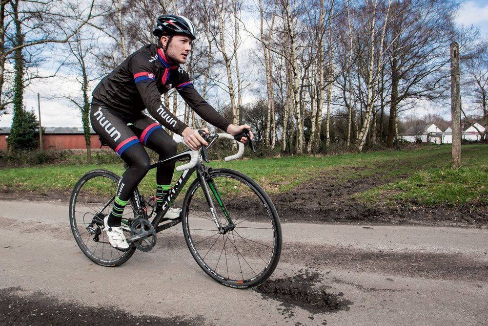 Cyclist riding over a pothole