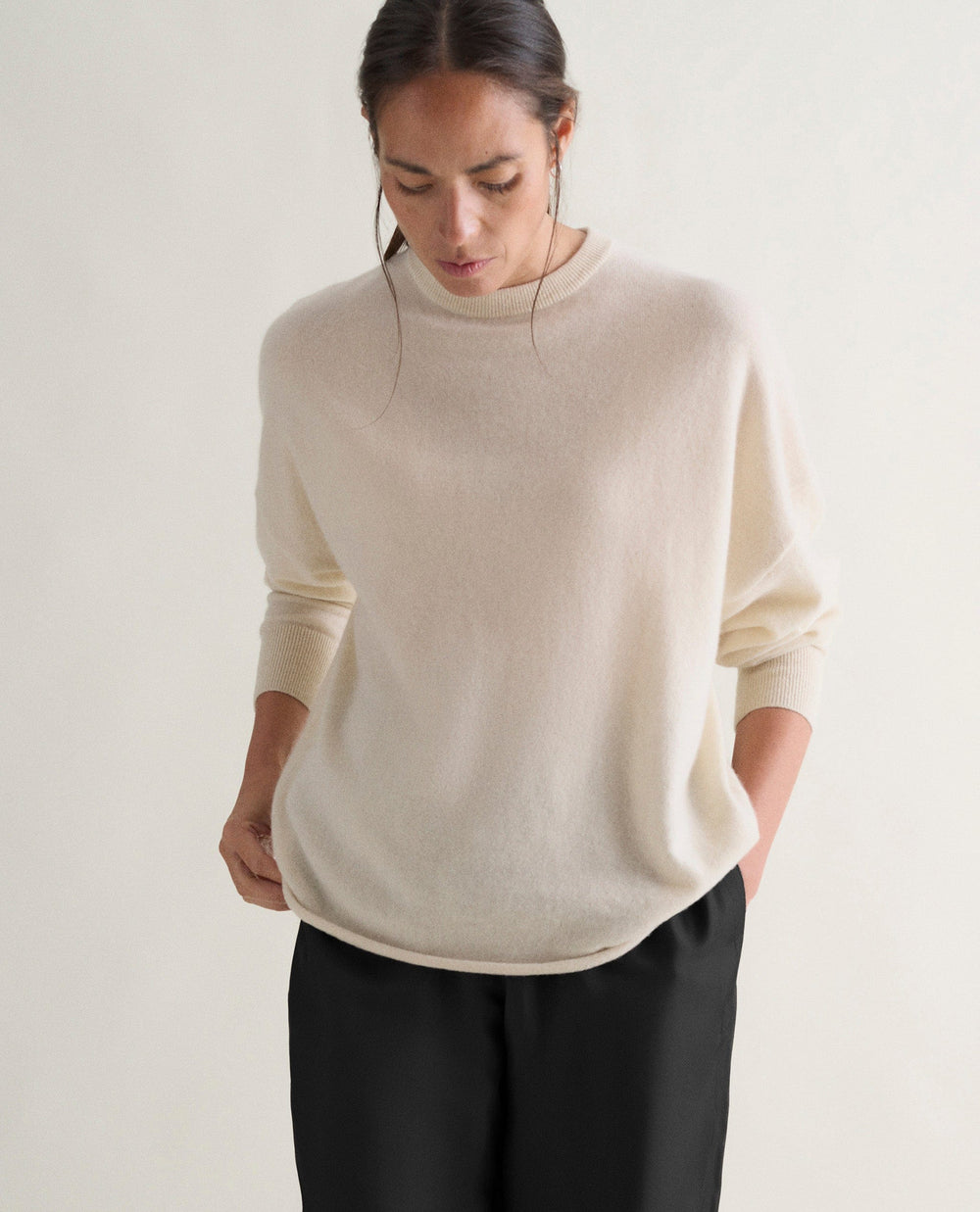 a model wearing a cream cashmere jumper from rise &amp;amp; fall
