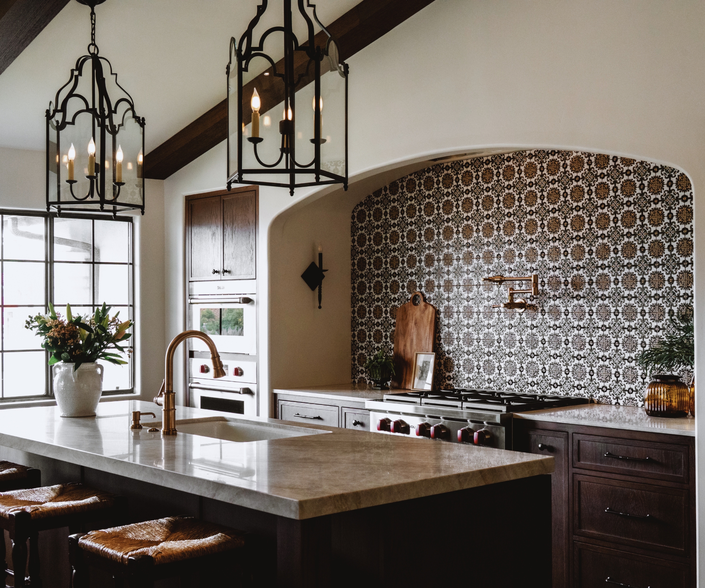 A fall kitchen with dark wood cabinets and layered lighting