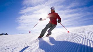 A man telemark skiing on a sunny day