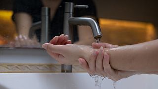 Running water on wrists to cool pulse point for how to keep cool in summer heat