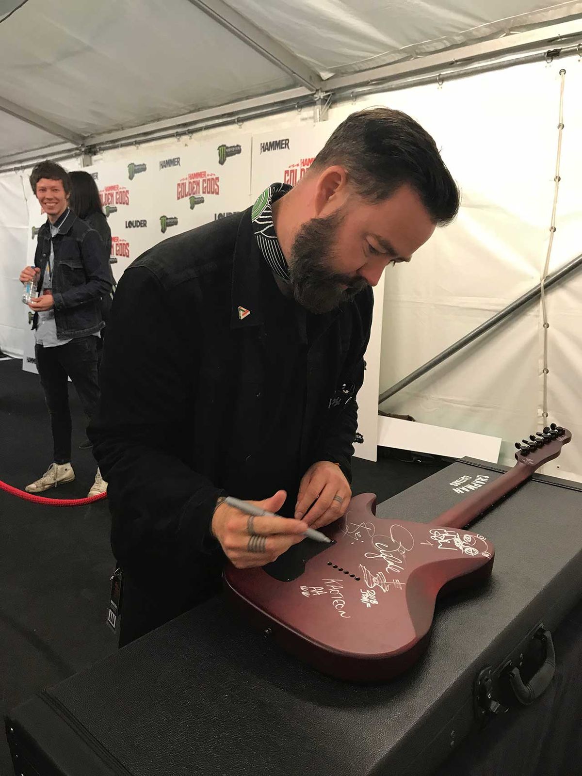 Daniel P Carter signing guitar