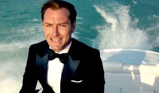 Spy Jude Law rides on a speedboat sharply dressed