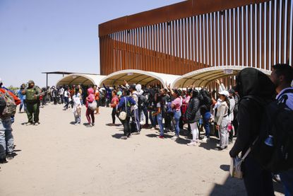 Migrants stand in line at the Southern border