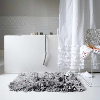 bathroom with white flooring and grey bath mat and white shower curtain