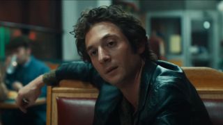 Jeremy Allen White sitting in a diner as Bruce Springsteen in the trailer for Deliver Me From Nowhere.