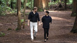 Prince Harry and Meghan Markle walk holding hands.