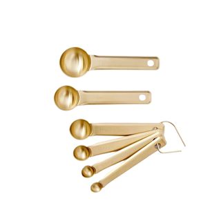 A set of six gold measuring spoons