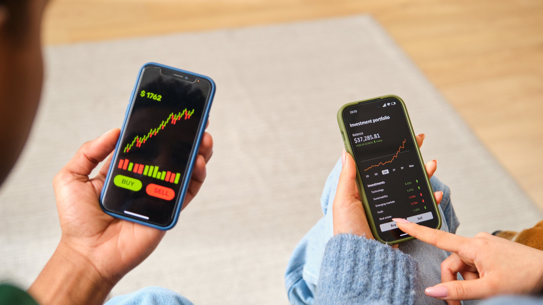 two people investing on their smartphones