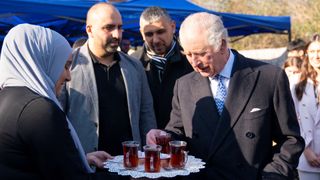 Britain's King Charles III (R) has a tea during a visit to the West London Turkish Volunteers, in Hounslow, greater London, on February 14, 2023, to meet members of the Turkish diaspora community who have been collecting, packaging and organising the transportation of food, blankets and warm clothing for people who have recently been affected by the earthquakes in Turkey and Syria. - The 7.8-magnitude earthquake on February 6 has killed at least 35,000 people and devastated swathes of Syria and neighbouring Turkey.