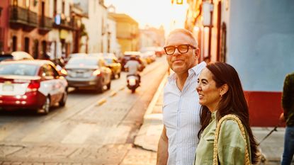 Smiling couple walking on city streets at sunset 