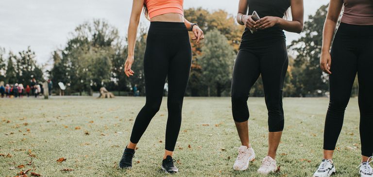 Woman in black gym leggings stand in a Park