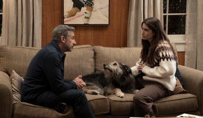 Steve Carell and Charly Clive sitting on a sofa with a dog between them in HBO's Rooster.