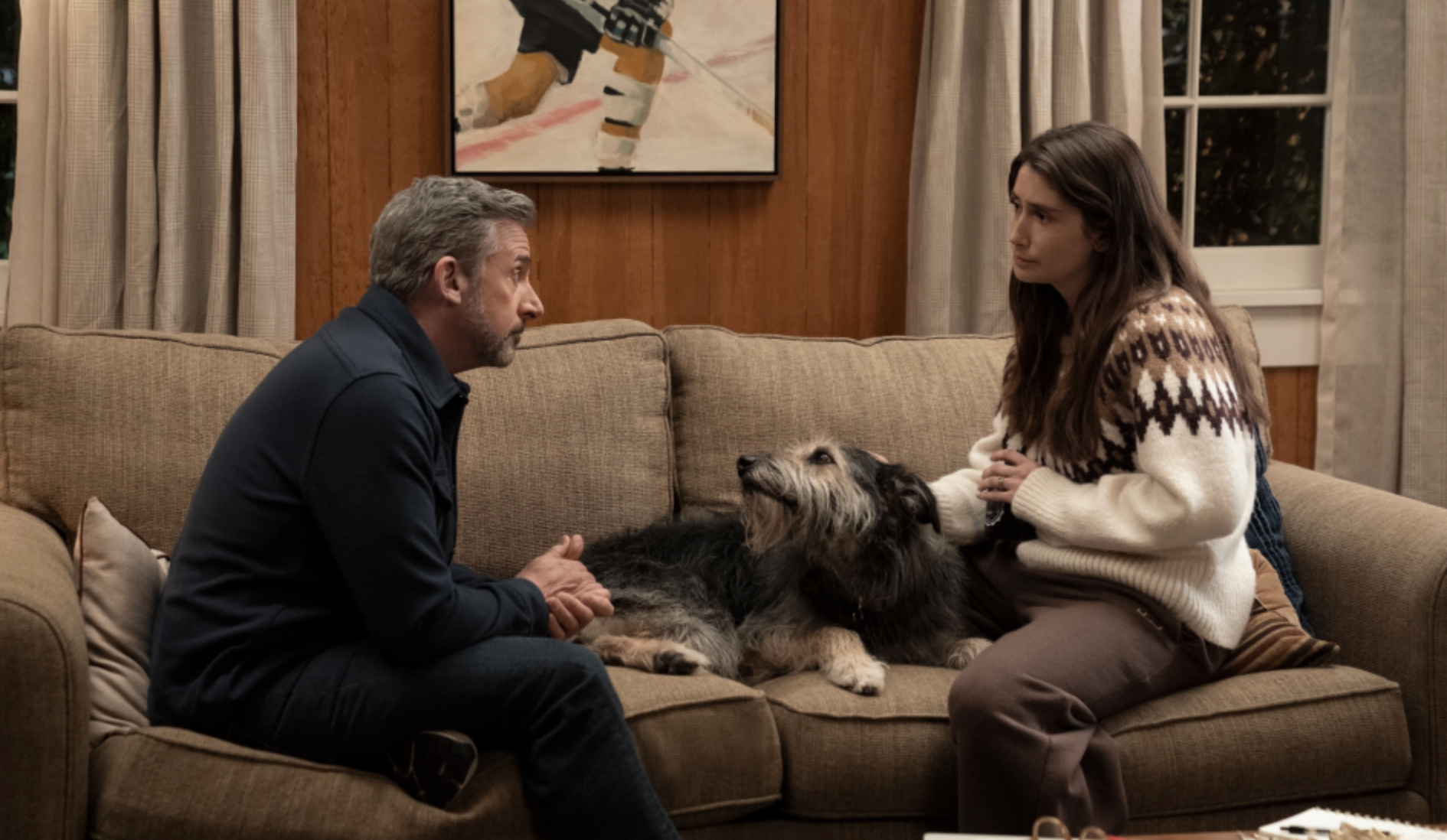 Steve Carell and Charly Clive sitting on a sofa with a dog between them in HBO's Rooster.