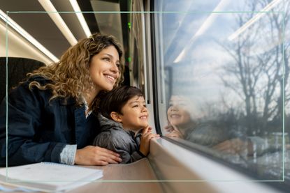 A woman and a child looking out of a train carriage window