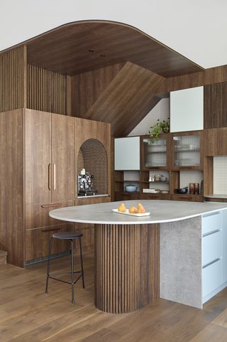 modern kitchen with rounded island and coffee niche in an arched wood cabinet