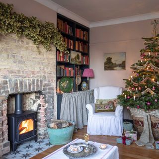 vintage style christmas living room exposed brick wall, wood burner and christmas tree