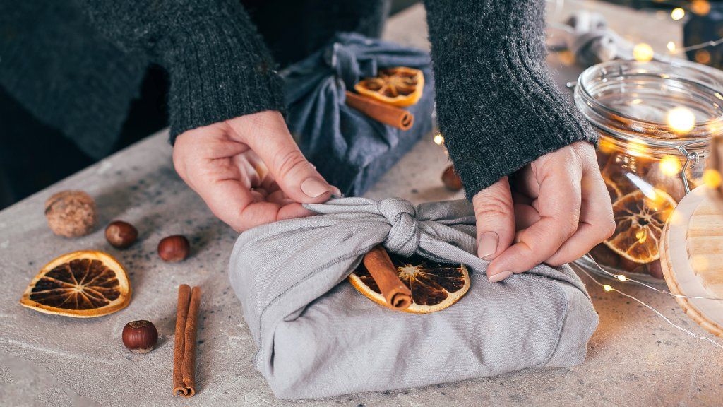 Hands holding a gift wrapped in fabric 