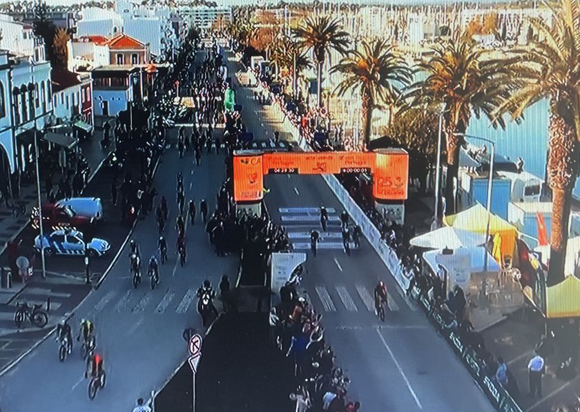 Only a few riders pass under the official finish banner, with most riders on the wrong side (left in photo) of the barriers