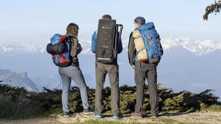Three hikers, one wearing Unistellar eVscope 2 packed into a backpack