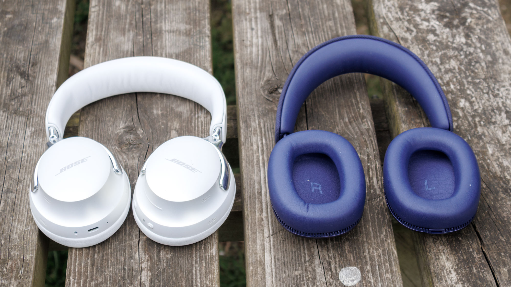 Bowers & Wilkins Px7 S3 vs Bose QuietComfort Ultra Headphones on a wooden surface, the inside of the drivers